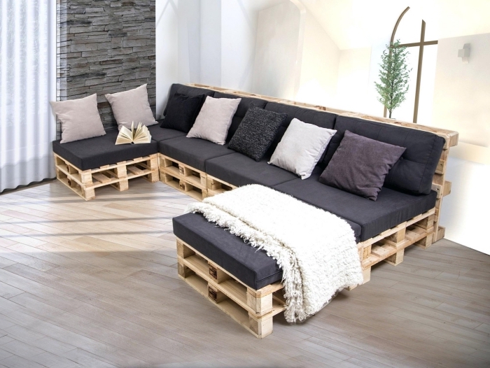 déco salon aux murs blancs avec meuble de bois et coussins décoratifs en couleurs neutres ou pastel, modèle de canapé en palette