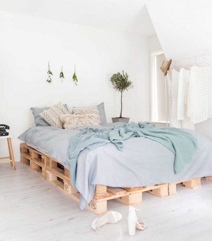 sommier en palette europe double hauteur dans chambre aux murs blancs avec déco minimaliste avec plantes vertes