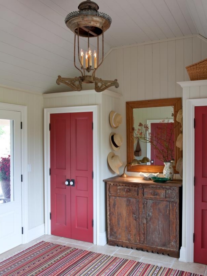 entrée rustique avec porte d'intérieur couleur rose sorbet qui s'harmonise avec le tapis à motifs ethniques