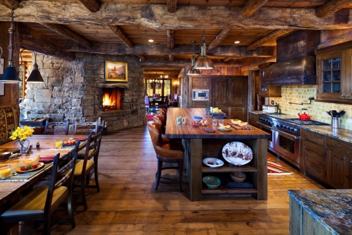 design intérieur cabine de bois avec une cuisine ouverte vers la salle à manger au plafond en poutres bois massif