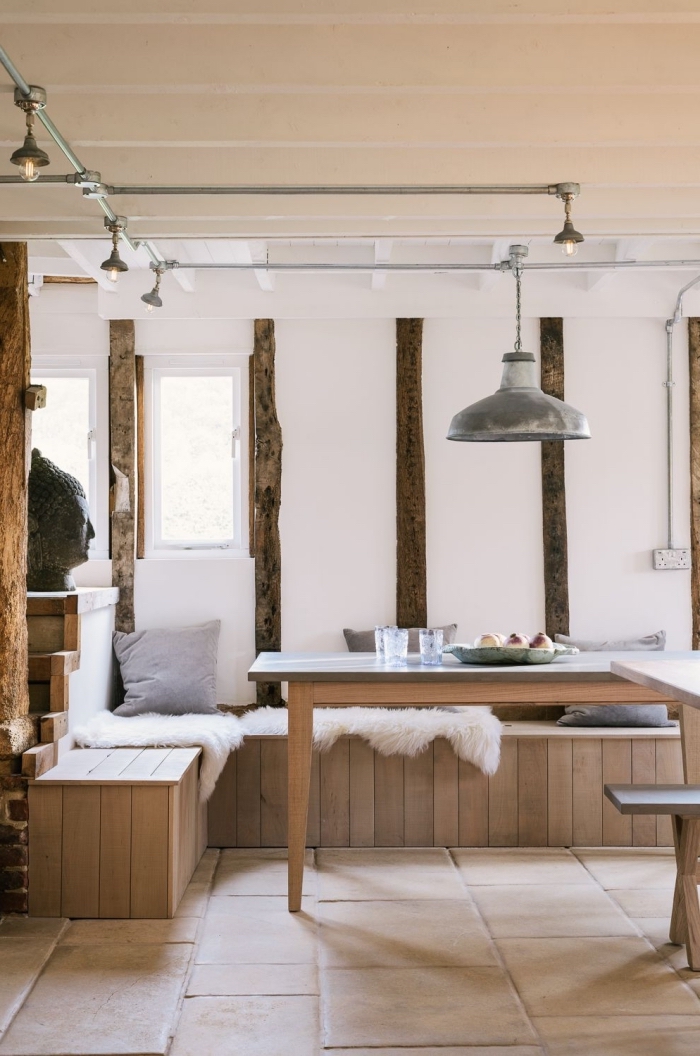 exemple de cuisine blanche et bois aménagée en style cozy avec décoration murale en poutres de bois foncé et carrelage sol beige