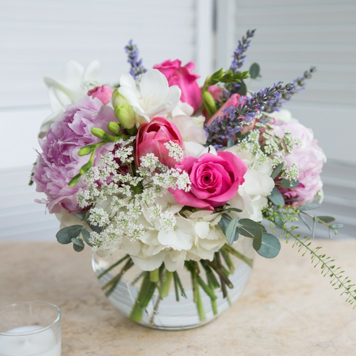 bouquet fleurs roses lilas et blanches mises dans un petit vase en verre, roses, hortensias et lilas