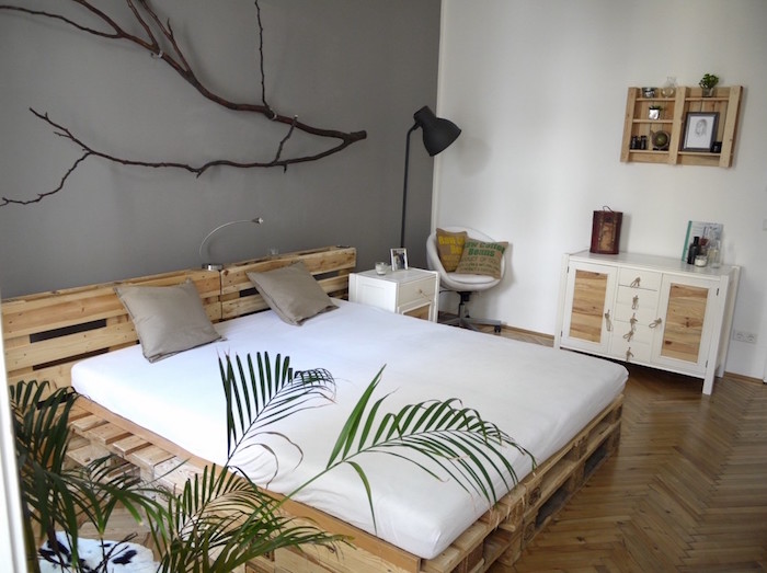 grand lit double adultes king size avec tete en palettes dans chambre déco nature avec mur blanc et gris