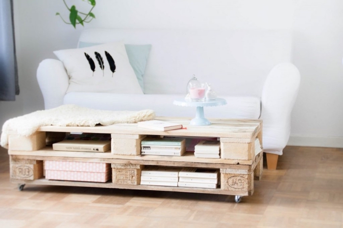 ambiance douce dans le salon avec un canapé blanc et une table palette d'aspect bois naturel décorée un présentoir pastel
