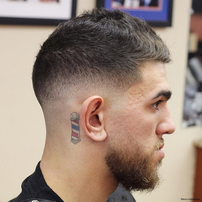 dégradé américain homme fondu avec tatouage derriere l'oreille et barbe blonde taillée