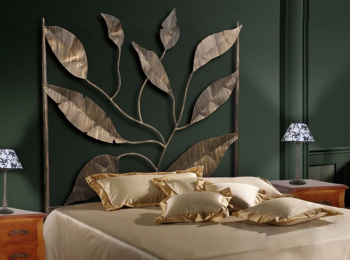 aménagement de chambre à coucher aux murs vert foncé avec tête de lit original à design feuilles métalliques aux reflets dorés