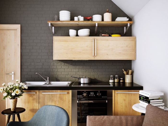 modèle de cuisine tendance aux murs et plafond blancs avec pan de mur en briques gris anthracite et meubles de bois clair