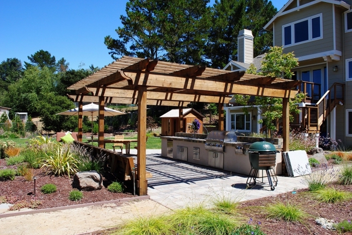idée comment aménager une cuisine d'été dans le jardin avec toit de bois massif et modules en béton et inox