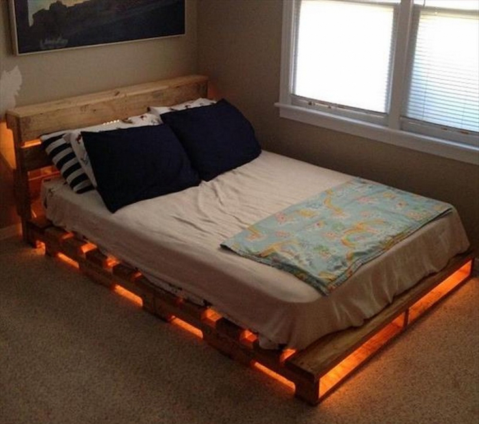 sommier en bois palette avec tete de lit et guirlande lumineuse sur moquette