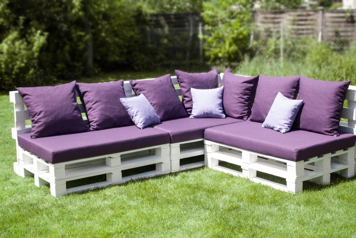 exemple de meuble DIY fabriqué en palettes de bois peint en blanc couvert de coussins et housses en violet