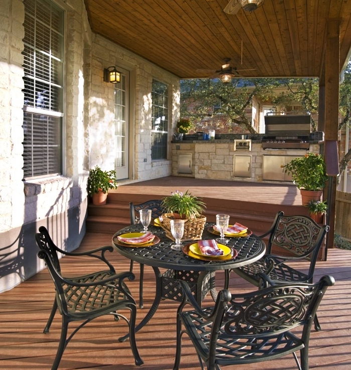 déco de terrasse avec table ronde et chaises en fer forgé, exemple evier exterieur sur coin cuisine en pierre et inox