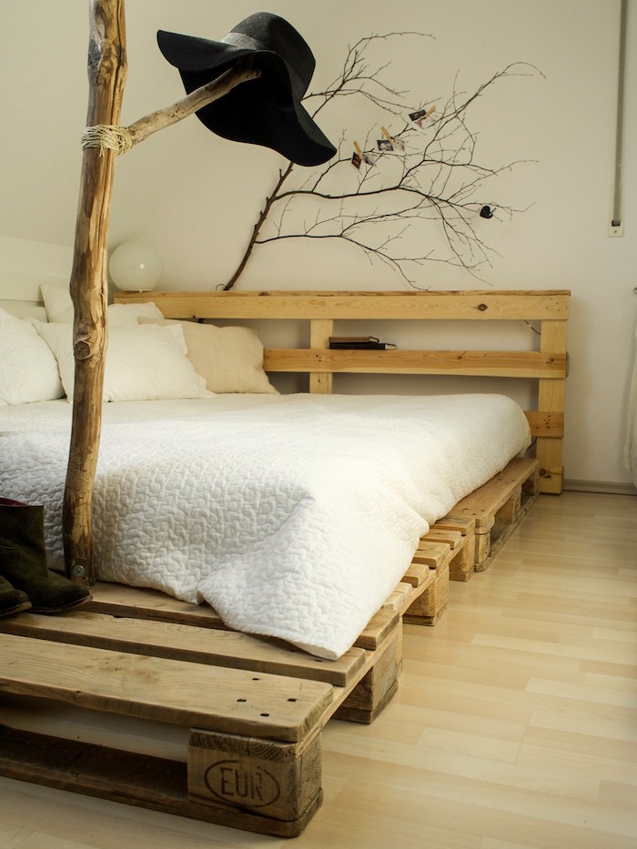déco rustique avec lit sommier en palettes bas et branches d'arbre pour décoration nature