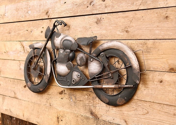 exemple de décoration murale en métal avec une motocyclette sculpture accrochée sur un mur de bois clair