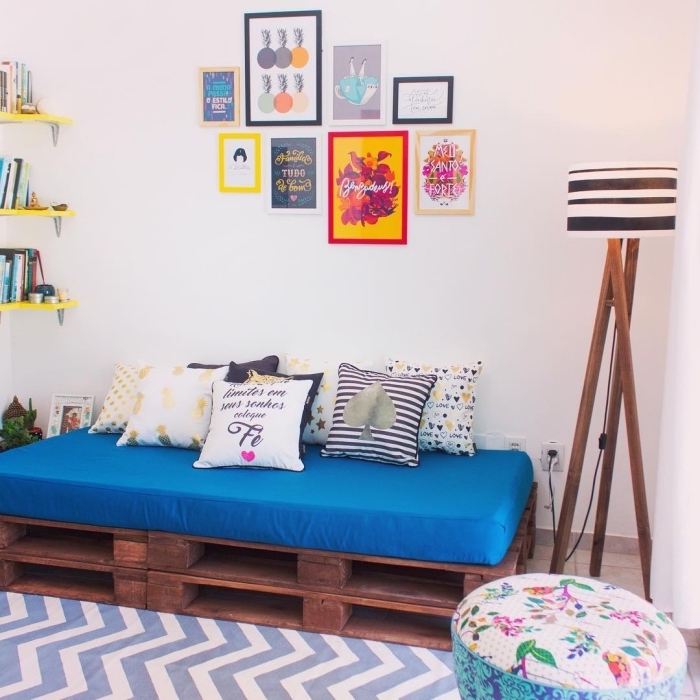 déco chambre ado avec un coin de lecture aménagé avec banc en palette couverte de coussins et mur de cadres