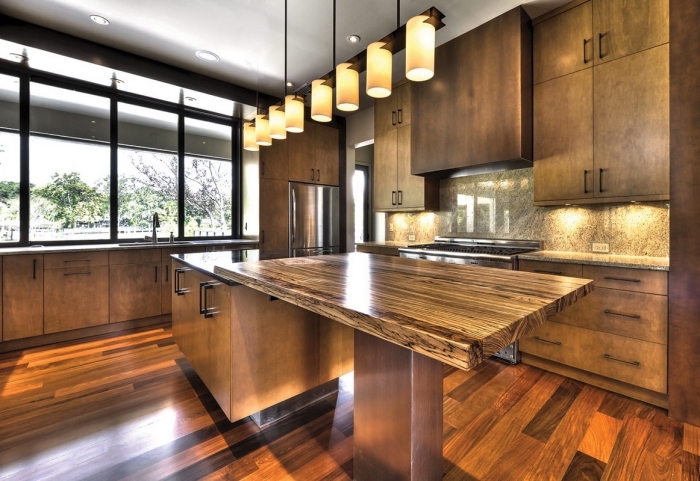 modèle de cuisine design bois foncé aux grandes fenêtres et plafond haut avec éclairage led et meubles foncés