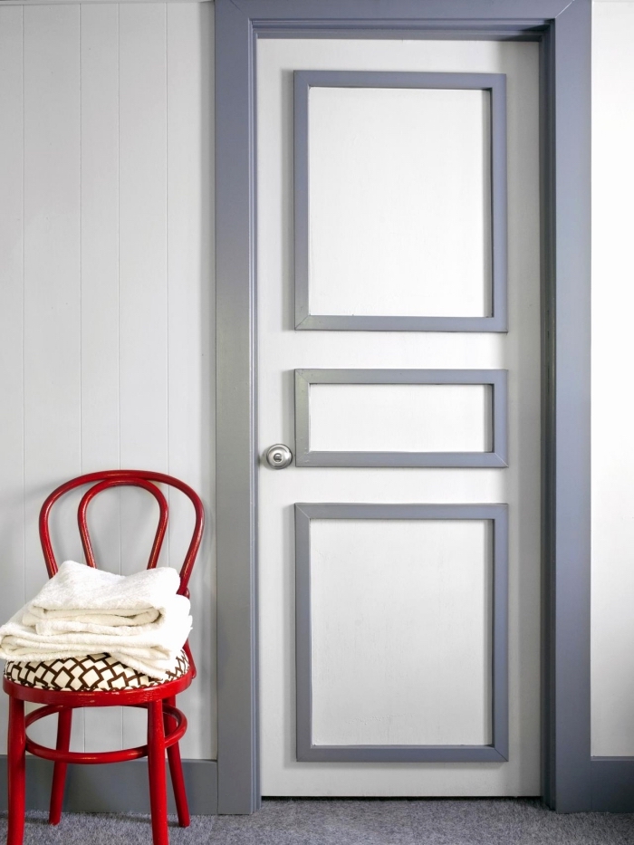 une porte d'intérieur à moulures et encadrement contrastant peints en gris, une porte plane décorée avec des moulures
