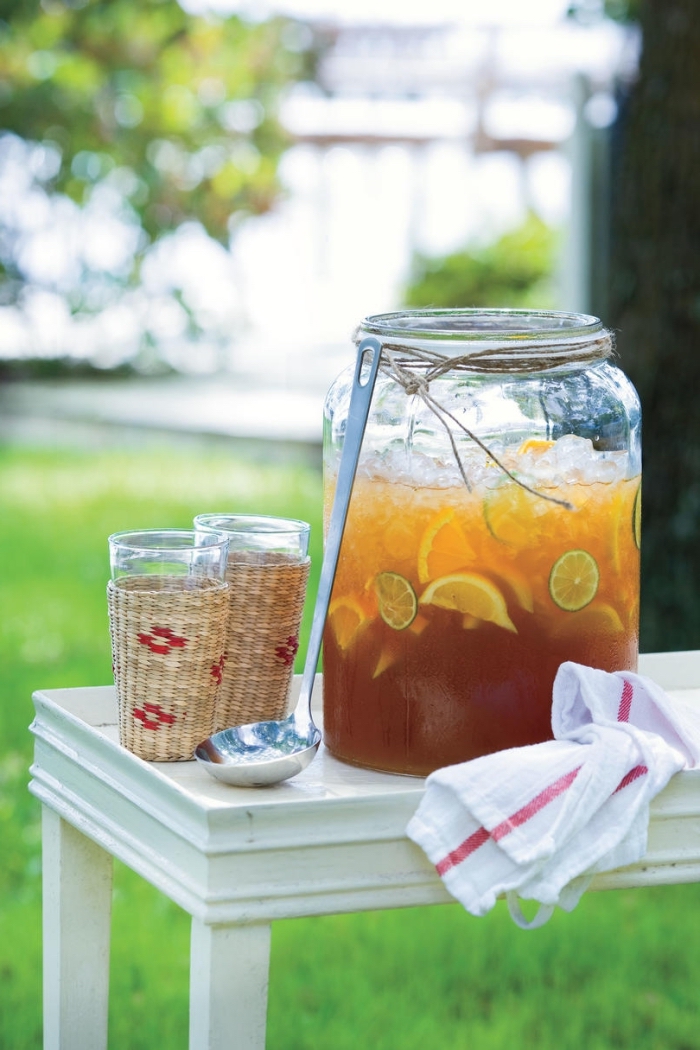grand pot rempli de citronnade maison aux agrumes et glaçons, idée boisson rafraîchissante pour un pique-nique