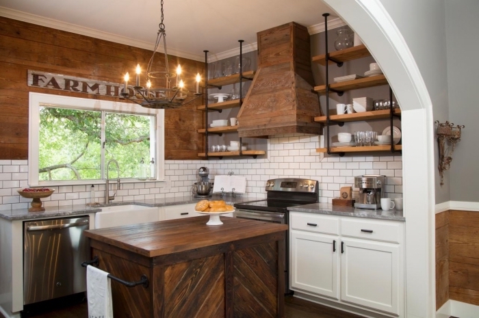 ambiance rustique dans une cuisine aux murs en revêtement bois foncé et crédence au carrelage briques blanches