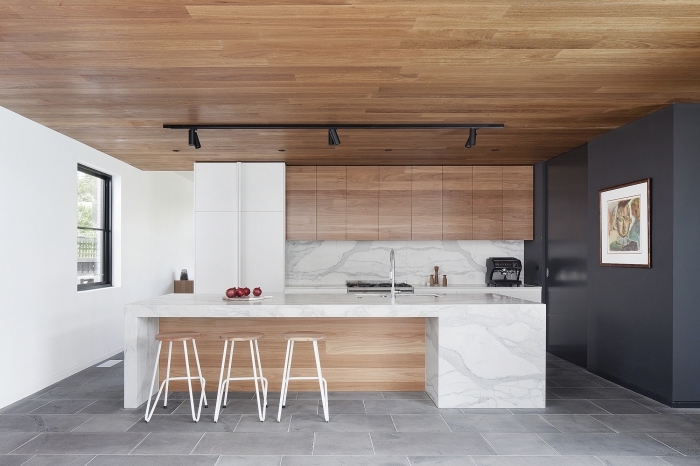 design intérieur moderne dans une cuisine ouverte avec ilot central marbre blanc et pan de mur en gris anthracite