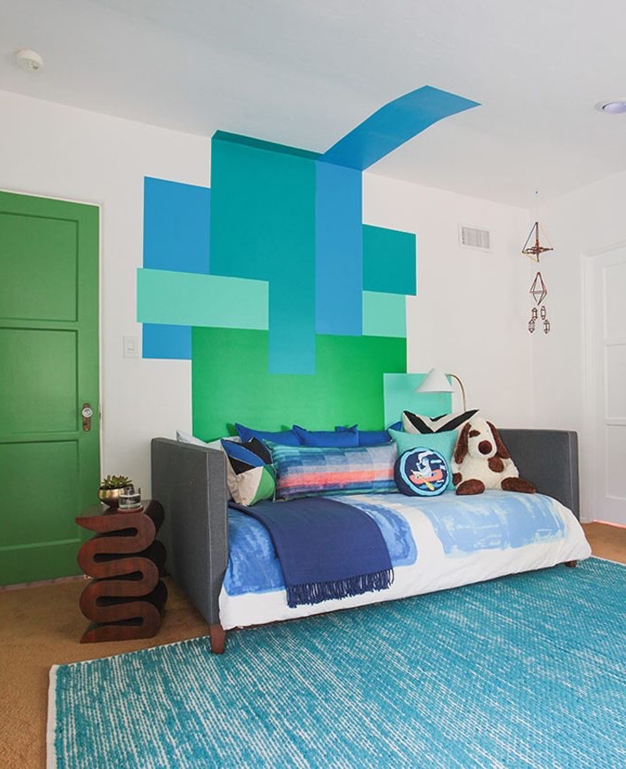 intérieur vintage aux nuances du bleu et du vert plein de fraîcheur, dynamisé par la porte d'intérieur couleur vert sapin mat et la peinture murale graphique