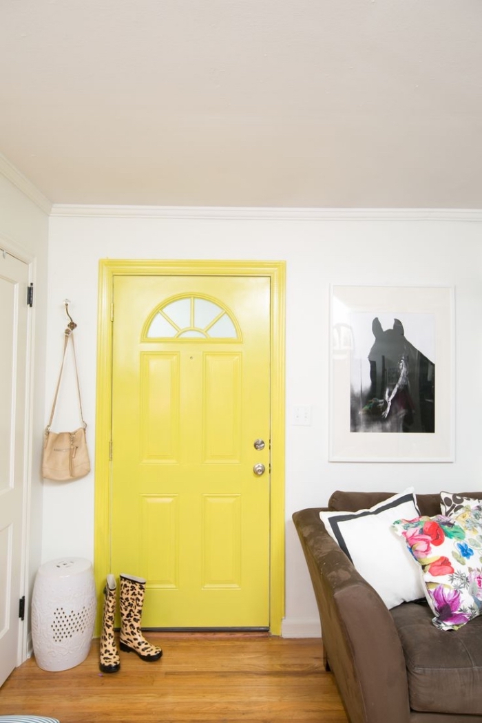 une porte d'intérieur jaune fluo et un poster mural noir et blanc pour une ambiance contemporaine dans le salon