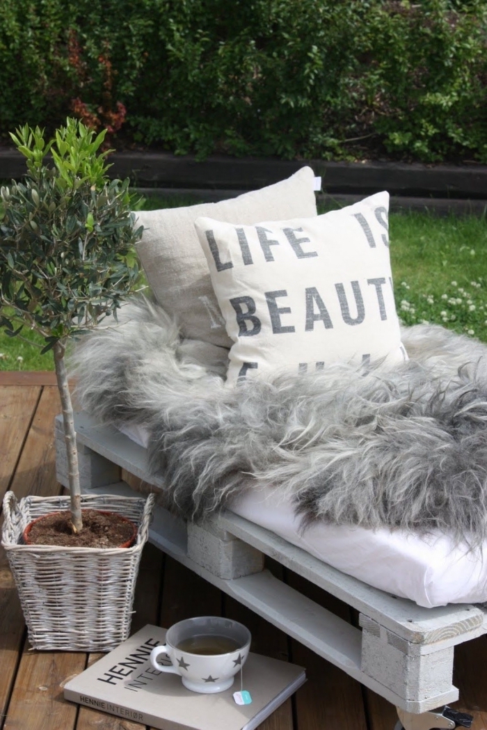 accessoires de style cocooning pour décorer un coin de repos extérieur avec meuble en palette et plantes vertes