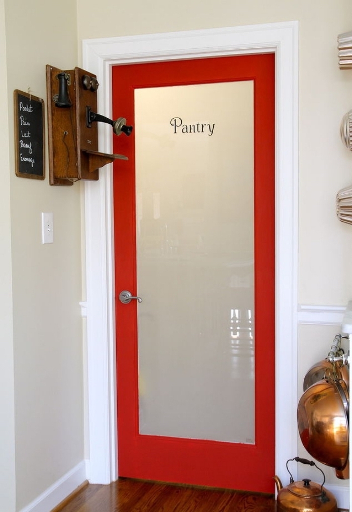 idée pour relooker une porte d'intérieur vitrée avec de la peinture, l'encadrement de porte rouge et blanc crée un joli accent coloré dans l'espace cellier