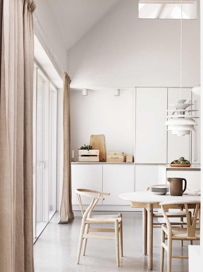décoration de style minimaliste dans une cuisine blanche équipée de meubles blanc et bois avec rideaux longs beige