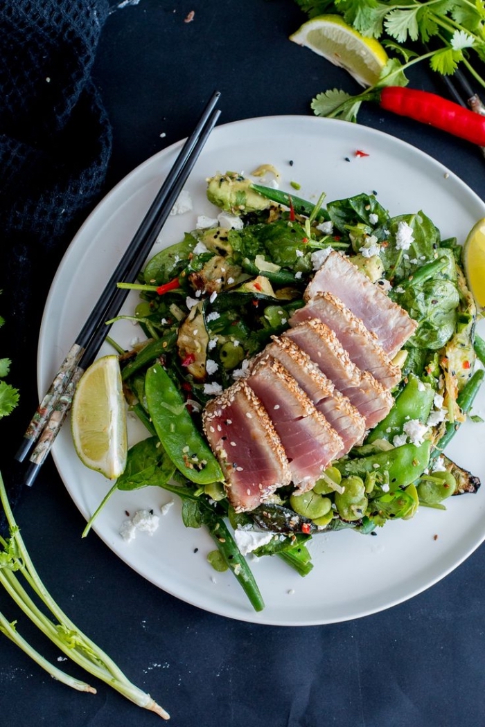 recette de salade verte composée inspirée de la cuisine asiatique, aux épinards, courgettes, pois mange-tout et avocat, servie avec du saumon mariné en croûte de sésame