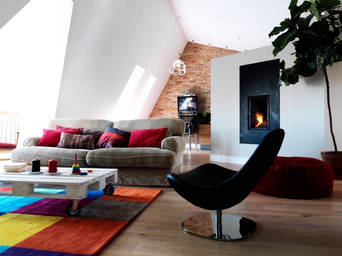 salon design moderne qui mixe les styles déco, une table basse palette blanche à roulettes joliment accentuée par le tapis milticolore