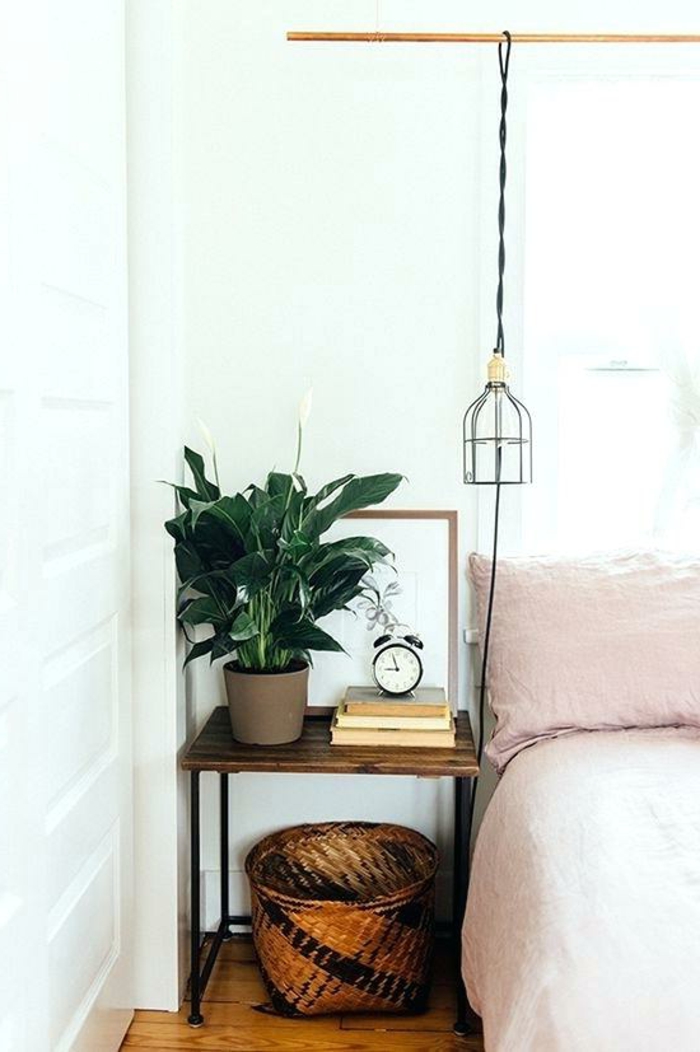 panier rustique sous une table de chevet en bois et fer, lampe cage pendante, linge de lit rose