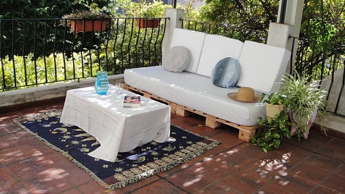 exemple salon de jardin palette avec canapé et table basse DIY couvert de nappe et coussins blancs, déco avec plantes vertes