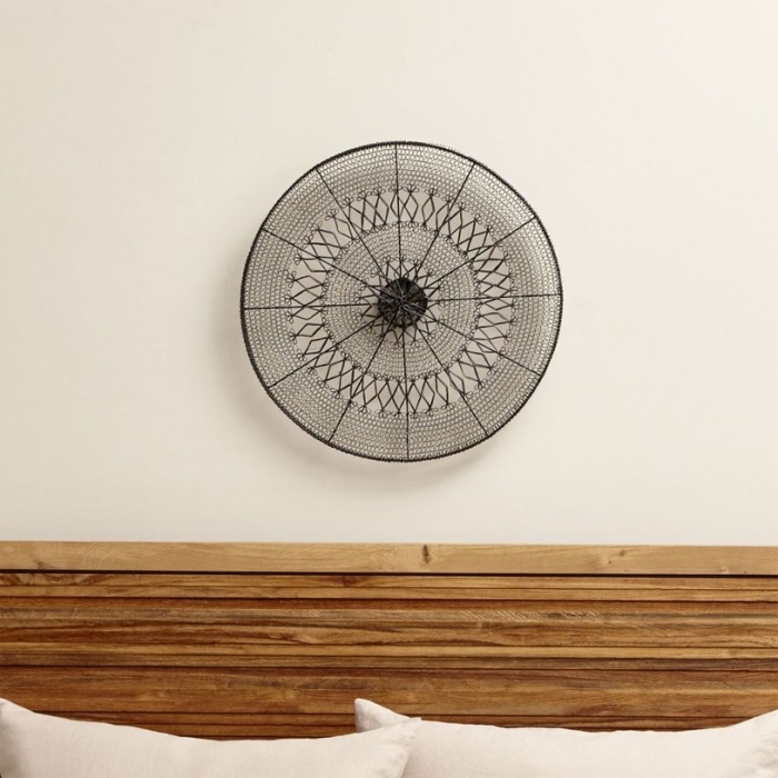déco de chambre à coucher avec tête de lit de bois marron et une création en fer à design mandala accrochée sur mur blanc