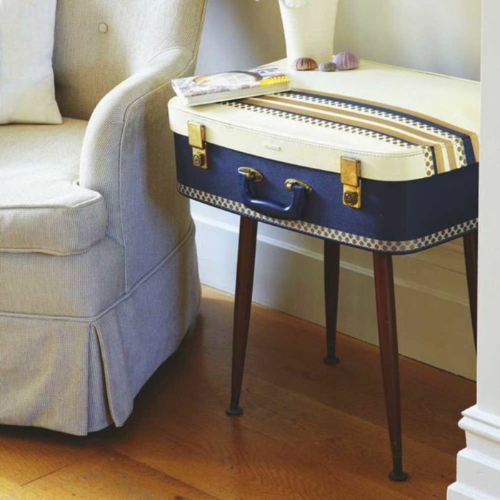 jolie valise utilisée comme table de nuit design, fauteuil gris, sol en bois