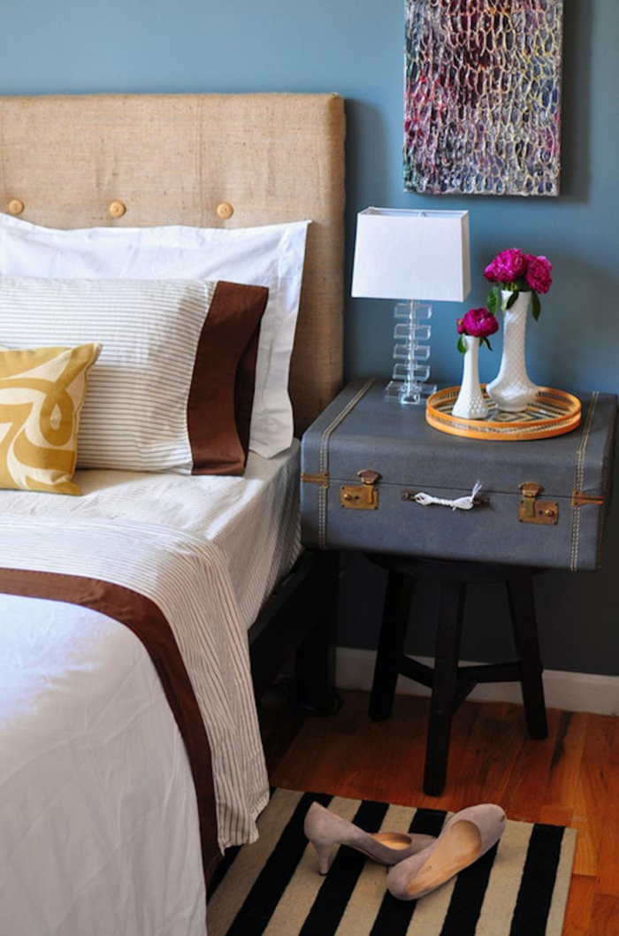 chambre bleue et blanche, valise vintage bleue, tête de lit beige, coussin en jaune et blanc