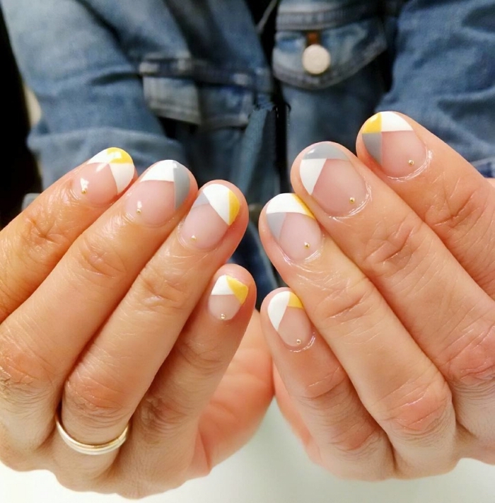 motif ongle géométrique à design français, nail art avec base transparente et dessin géométrique en blanc gris avec accents jaunes