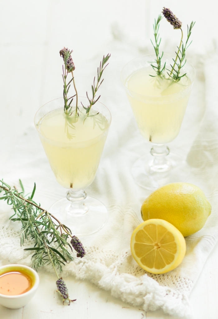 recette citronnade fraîche préparée à la maison au jus de citron et eau froide à garnir avec branches d'herbes vertes