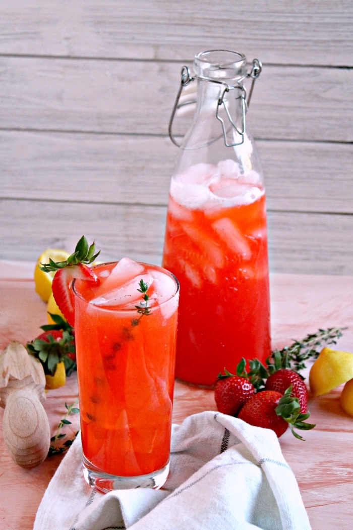 exemple de boisson rafraichissante aux fruits et eau avec glaçons dans un verre cocktail décoré de fruits et d'herbes