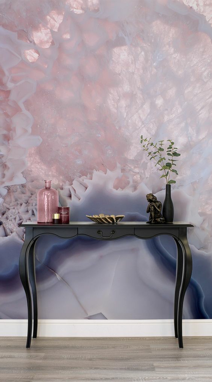 murs au papier peint aux effets 3D, nuances nacrées en couleur rose pale et bleu saphir, meuble d'entrée en bois peint en noir, avec petit vase noir et bocal en couleur rose poudré 