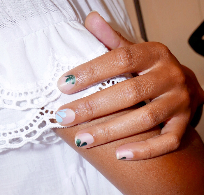 Feuilles vertes et un ongle avec feuille bleu claire manucure estival pour ongles courts vernis blanc semi-transparent
