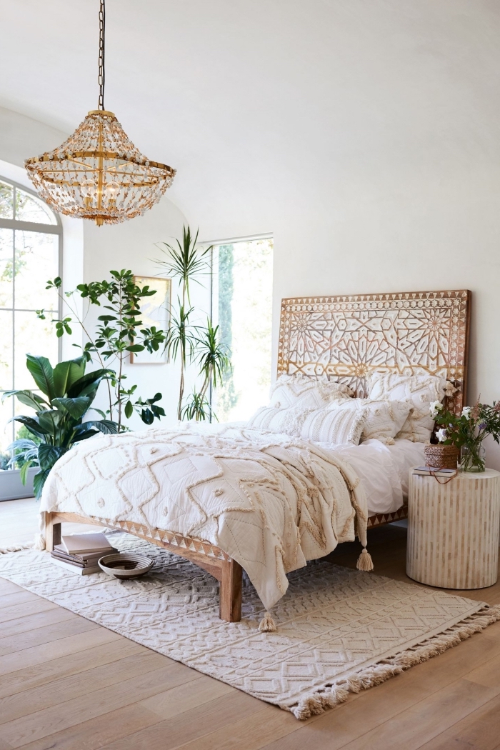 design chambre à coucher de style bohème aux murs blancs avec plancher de bois clair et tête de lit de bois à design mandala