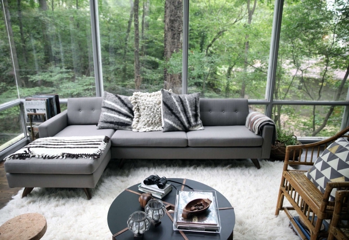 exemple comment décorer un salon moderne avec grandes fenêtres et parquet de bois, modèle de canapé d'angle en gris