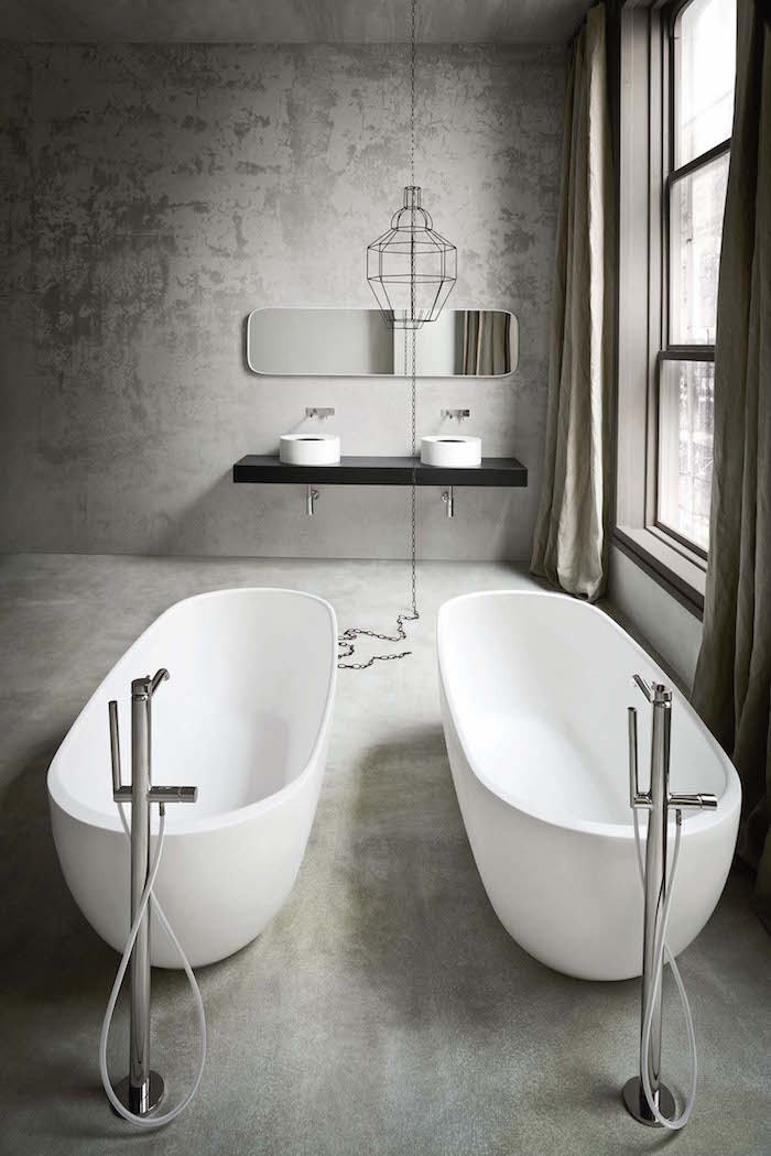 modèle salle de bain en béton ciré avec enduit ciment sur le sol et les murs avec duo de baignoires ilots