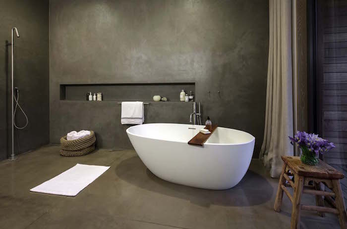 salle de bain tout en béton ciré sur sol et murs gris anthracitre avec baignoire ilot et douche italienne déco design