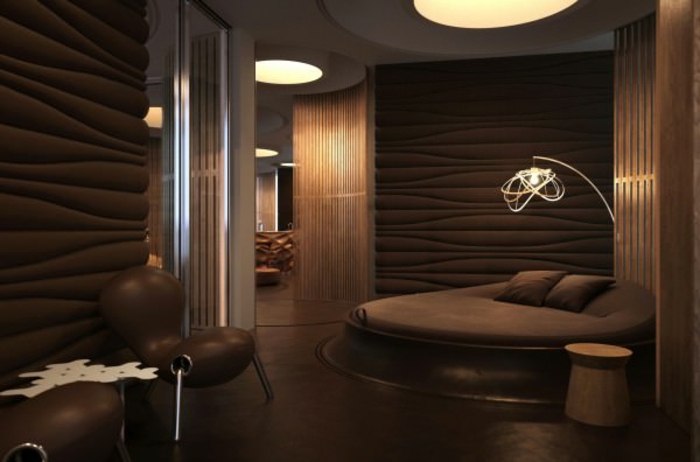 chambre originale déco wengé, lit rond, chaises futuristiques, parement mural marron