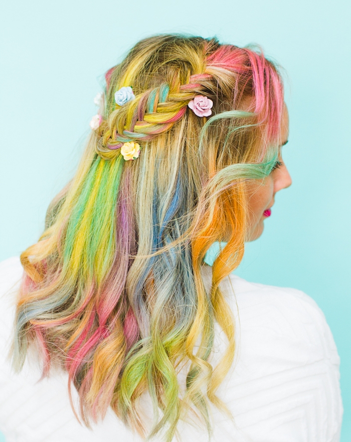 cheveux-arc-en-ciel-lachés-ondulés-avec-une-tresse-épi-latérale-petites-fleurs-artificielles-pour-parer-les-cheveux coiffure avec tresse épi de coté, cheveux arc en ciel colorés, décoration de petites roses décoratives