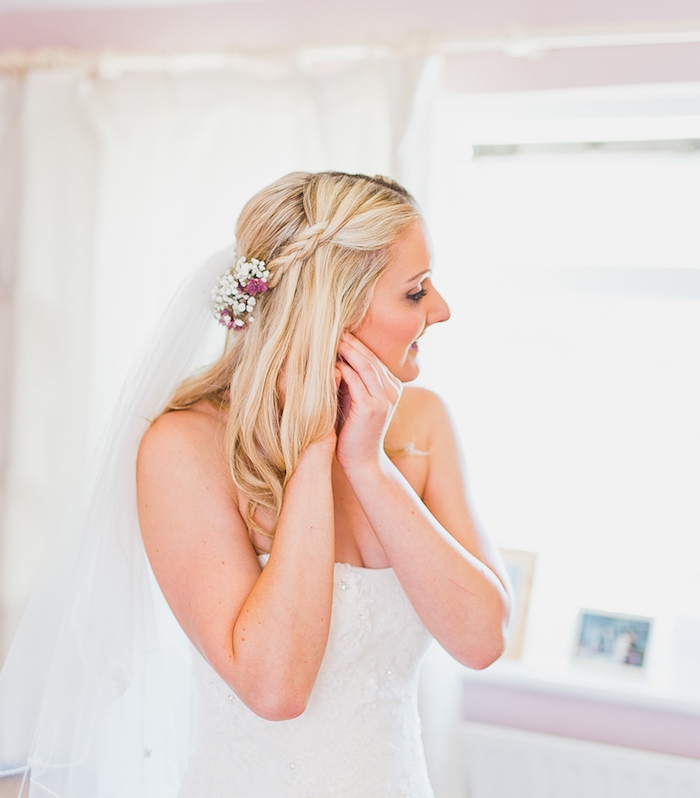 robe de mariée simple avec une demie tresse latérale, voile blanche et décoration accessoire fleurs fraiches