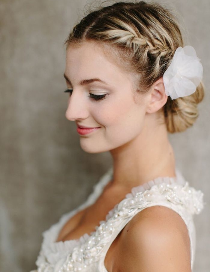coiffure-chignon-tresse-petite-de-coté-cheveux-accessoirisés-d-une-fleur-blanche-coiffure-mariage-cheveux-mi-long quelle coiffure chignon tresse, tresse de coté qui finit par un chignon simple et accessoire fleur en tissu