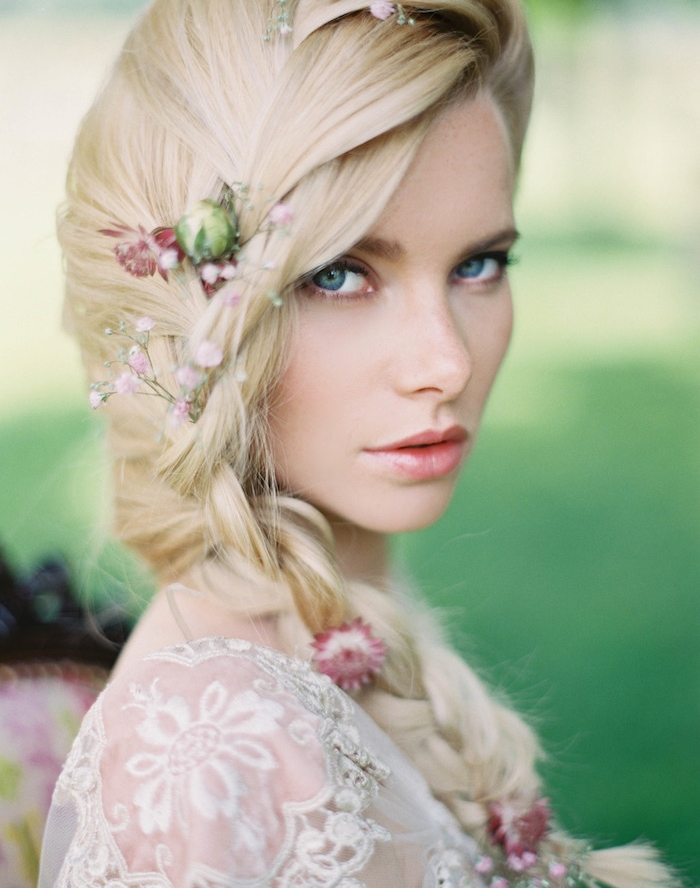 modèle de tresse sur le coté avec des fleurs champetres dans les cheveux, robe de mariée motifs floraux