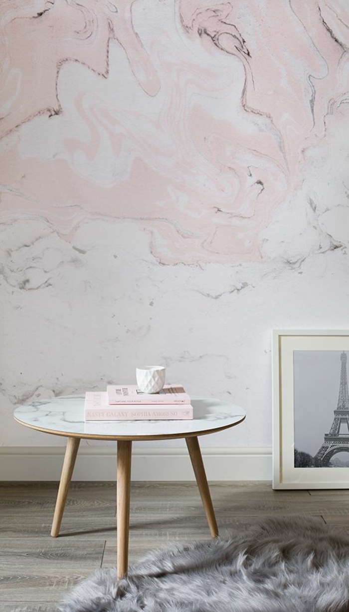 deco rose poudré sur les murs aux papiers peints motifs marbrés en rose et blanc, petite table basse ronde avec plan en blanc, parquet aux nuances grises et beies